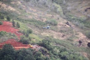 Helicopter fly over canyon to construction site